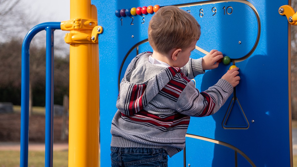 toddler in a program playing with the playground manipulatives